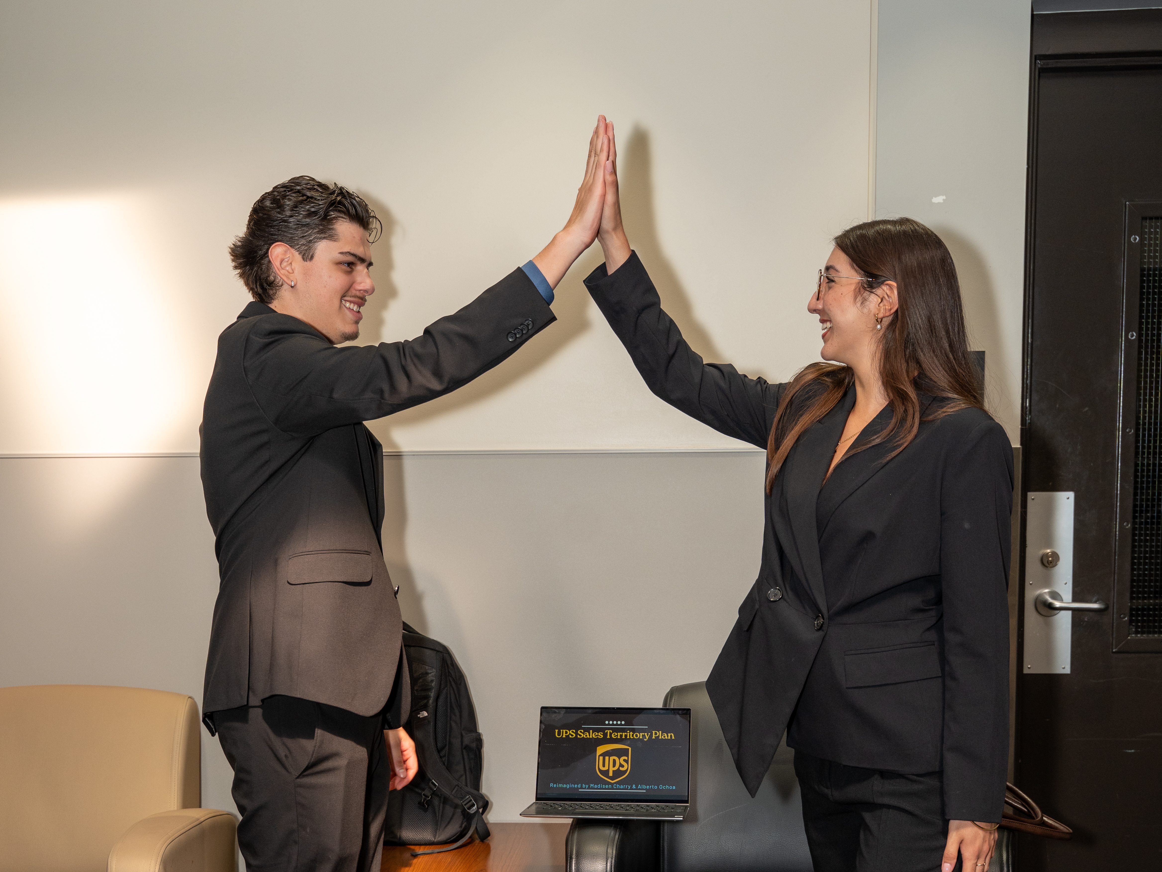 IB Students representing UPS team high-fiving.